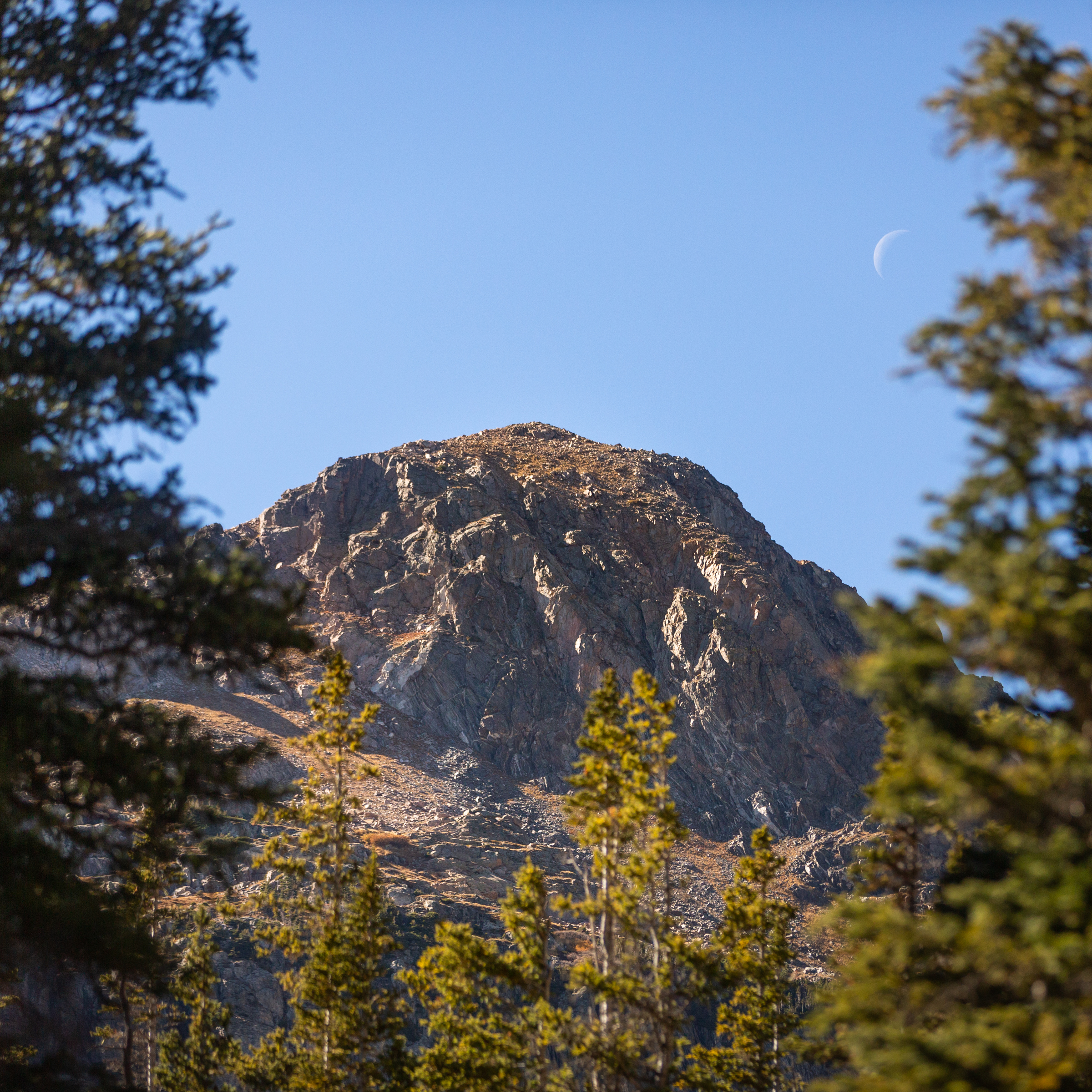 The moon peeking over the peak.
